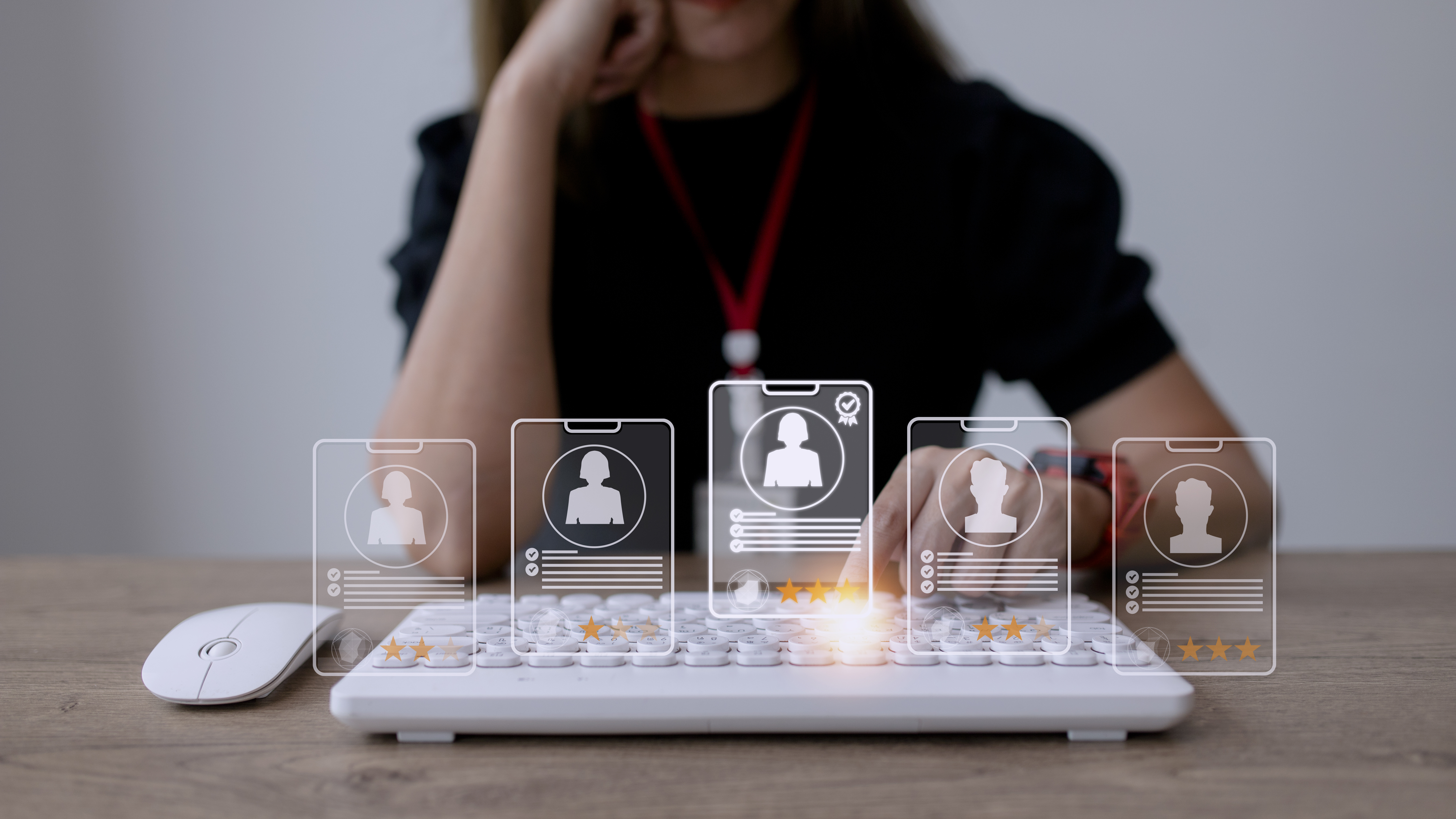 Person wählt digitale Profile mit Bewertungssternen auf einer Tastaturoberfläche.