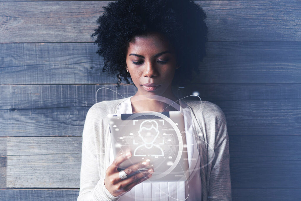 Tecnología y comunicación futuristas. Hermosa chica negra sonriente con peinado afro usando una tableta digital o un panel táctil, revisando el correo electrónico o escribiendo mensajes. Conexión mundial